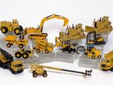 des véhicules de chantier miniatures sont disposés en cercle sur une surface blanche