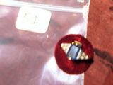 une bague sertie d'une pierre bleue, posée sur un sac