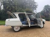 a white car with its doors open on a gravel road