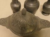 a silver teapot sitting on a table next to other silver teapots