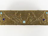 brass plate with blue glass beads on it on a white surface