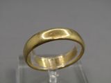 un gros plan d'une bague en or posée sur une surface transparente