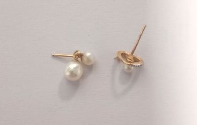 deux paires de boucles d'oreilles en perles et en or posées sur un fond blanc
