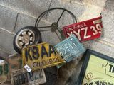 un tas de plaques d'immatriculation par terre, à côté d'une roue