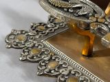 a silver plate with a bird on it on a table
