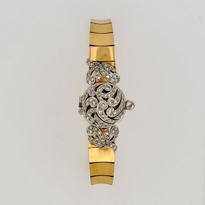 a close up of a gold and diamond watch on a white surface