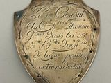 une plaque fixée au mur d'un immeuble sur laquelle figurent des inscriptions