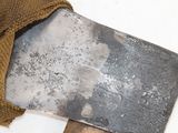 a large knife that is laying on a piece of wood