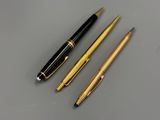 two pens and a ballpoint pen sitting on top of a table
