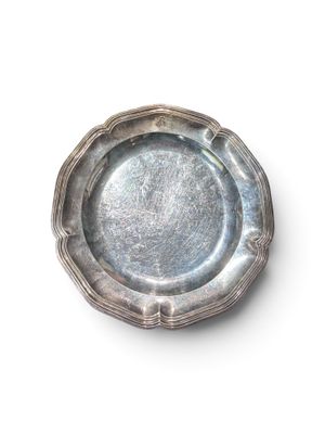 une assiette en argent posée sur une surface blanche