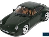 a green toy car that is sitting on a white surface