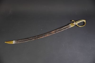 an old sword with a gold handle on a black surface