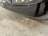 a black cat sitting on the front of a black car
