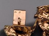 a gold plated toilet with a statue of a man sitting on it