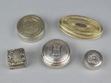 some silver metal buttons and a silver ring on a white surface