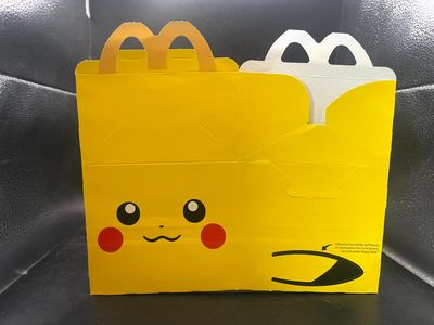 a close up of a yellow bag with a face on it
