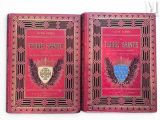 deux livres rouges aux tranches dorées, ornés d'un blason bleu sur la couverture