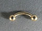 a close up of a gold nose ring on a gray surface