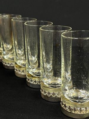 six verres alignés les uns à côté des autres sur une surface noire
