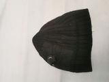 a black hat that is laying on top of a white sheet