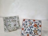 deux petites assiettes ornées de fleurs, posées sur une table