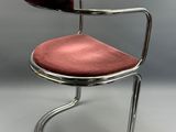 une chaise rouge posée sur un piètement métallique