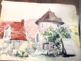 une photo d'un tableau représentant une maison, posé sur une table