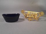 a black bowl and a gold plate on a table