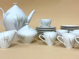plusieurs tasses et soucoupes et une théière sur la table