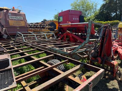 un tracteur qui est garé dans l'herbe, près d'autres tracteurs