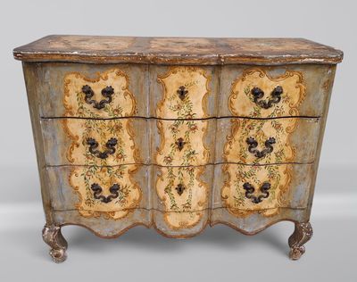 une vieille commode dont les tiroirs sont ornés de motifs floraux