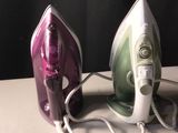 deux fers à repasser électriques posés sur une table à côté d'un sèche-cheveux