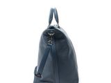 the large blue handbag is sitting on a white surface
