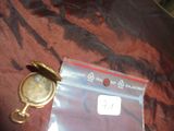 une montre de poche en or posée sur un sac en plastique