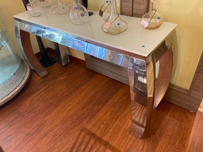 a glass table with vases on it in a room