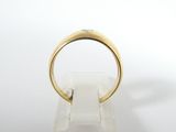 a close up of a gold ring on a clear stand