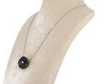 necklace on a mannequin neck with a black flower on it