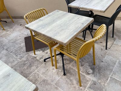 une table et des chaises qui se trouvent dehors, sur la terrasse