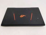 a black laptop with a orange logo on the screen