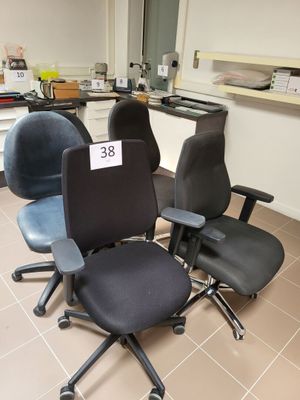 trois chaises de bureau dans une pièce, avec une étiquette de prix fixée à l'arrière