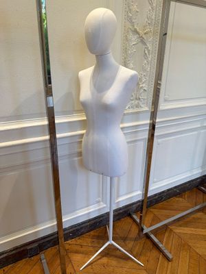 deux mannequins posés sur des socles dans une pièce au sol en parquet