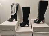 trois paires de bottes noires sont empilées les unes sur les autres