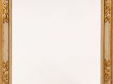 un miroir à cadre doré, sur fond blanc, accroché à un mur blanc