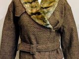 un mannequin portant une jupe verte et une veste marron