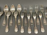 a lot of silver spoons and forks on the table