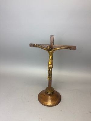 un crucifix en laiton surmonté d'une croix en bois