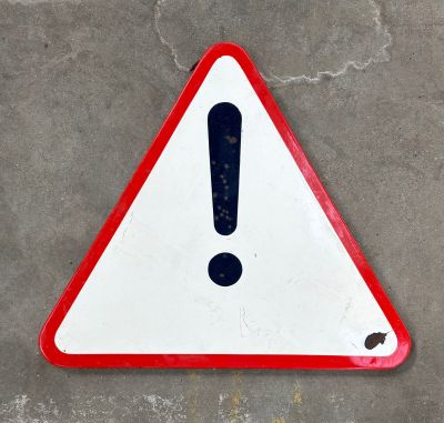 un panneau rouge et blanc sur lequel figure un point d'exclamation noir