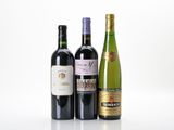 three bottles of wine sitting next to each other on a white surface