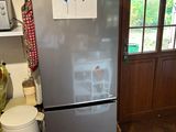 a refrigerator in the kitchen with a lot of magnets on it