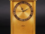 an image of a gold clock with roman numerals on the face